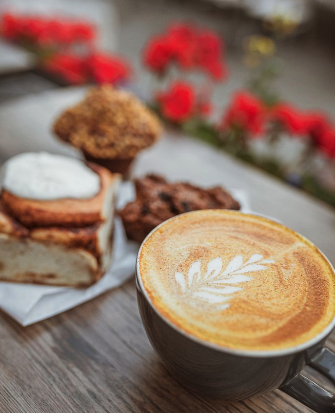 a cup of coffee sitting on top of a wooden table