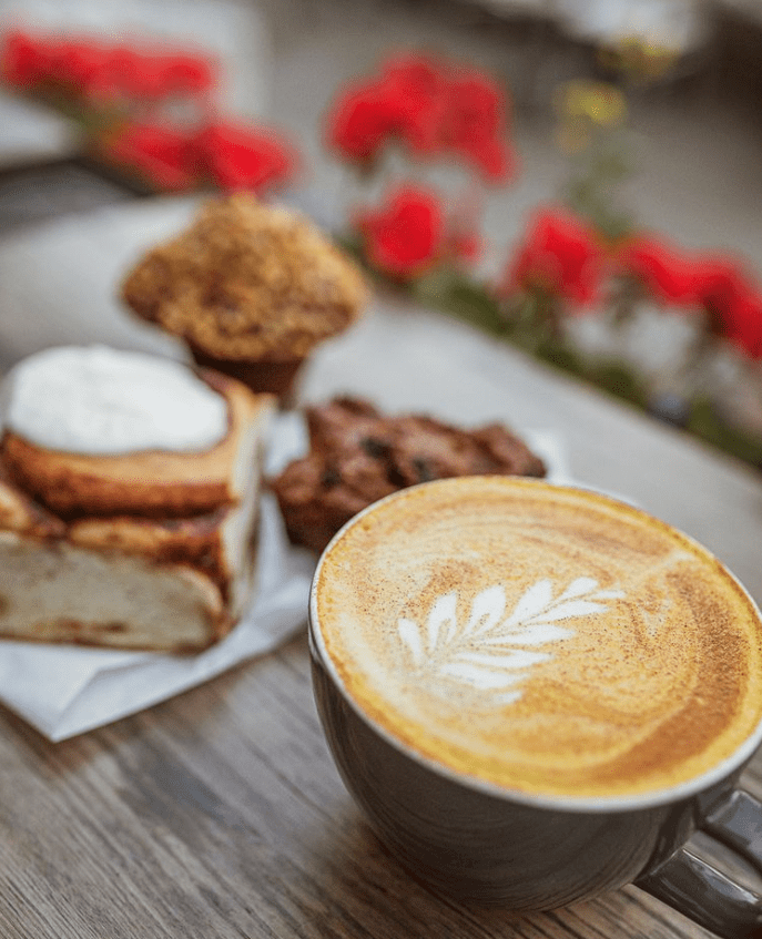 a cup of coffee sitting on top of a wooden table