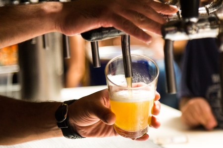 A bar tender pouring a beer from a tap