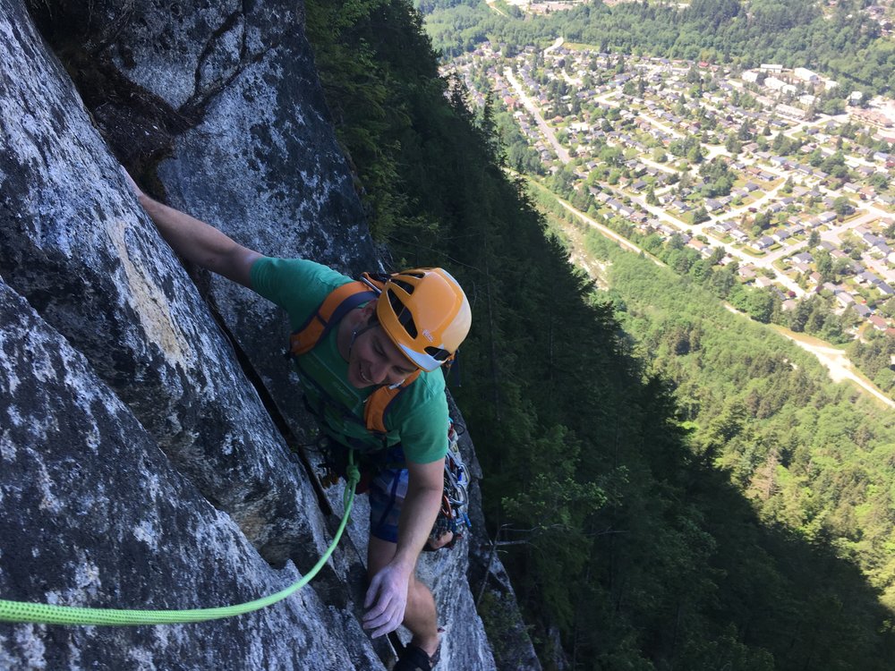 A view looking down the rock face of someone climbing