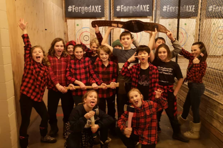 Friends wearing red & black shirts holding axes