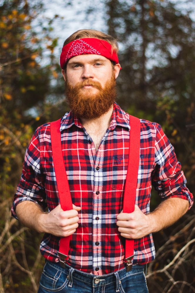 Lumberjack with suspenders, and beard, looking into the camera