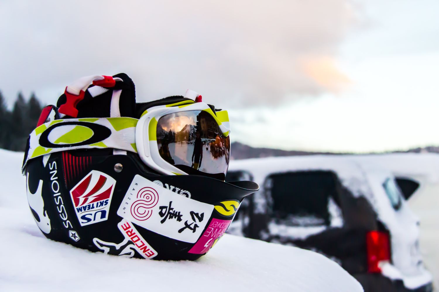Ski helmet sitting on a car, in snow