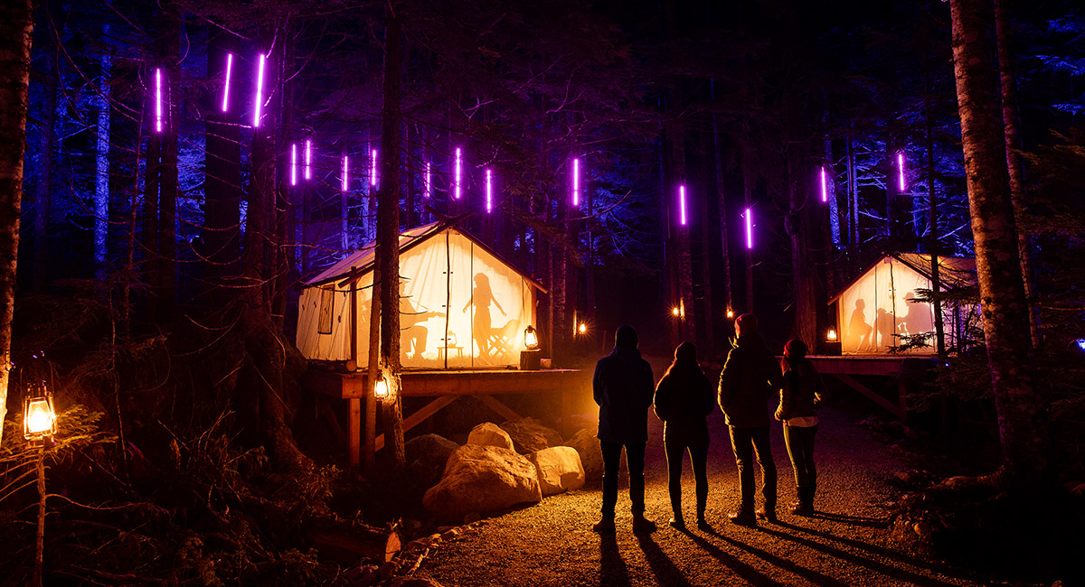 a group of people walking down a street at night