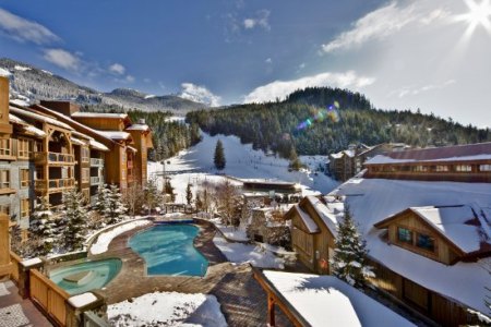a hotel covered in snow, overlooking blue pools