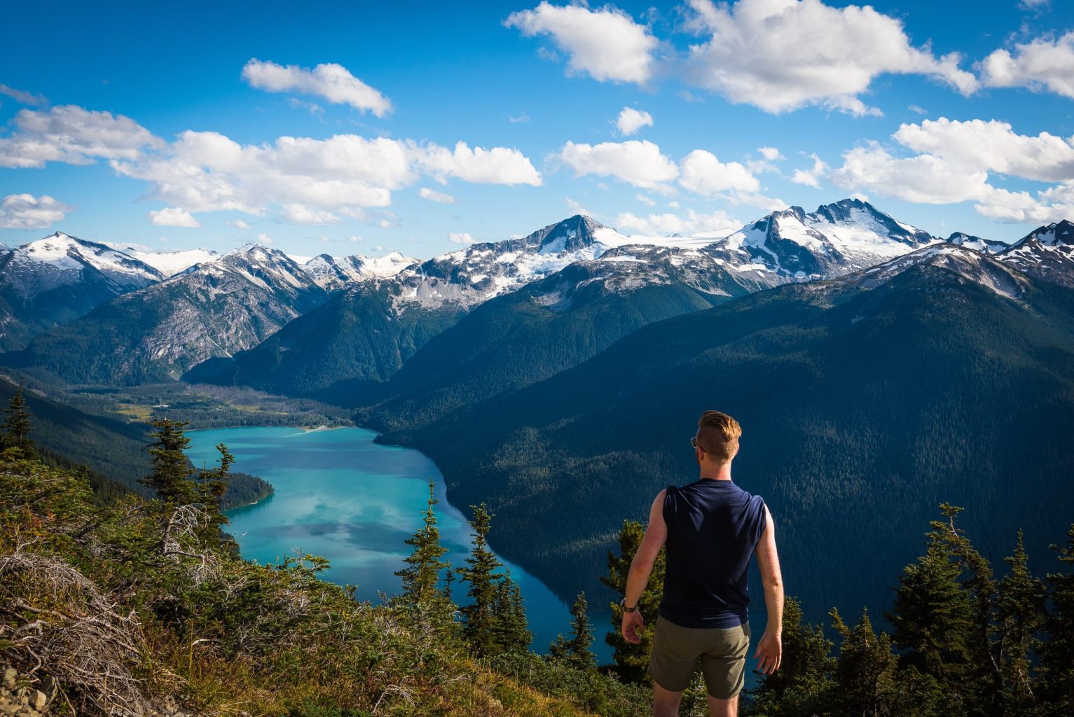 Man standing on mountain overlooking lake in Whistler