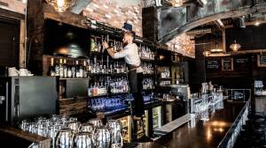 a bartender stocking the bar on a ladder