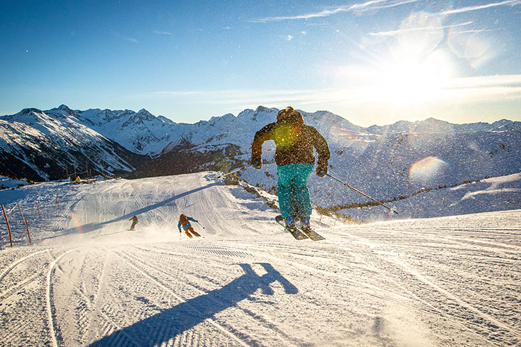 a man riding a snowboard down a snow covered mountain